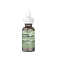 A small amber glass dropper bottle with a white cap and a pale green label, centered on a plain white background. The label text appears to read 'Soyfermented Vitamin B Complex'.