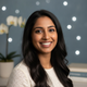 Headshot portrait of a happy, smiling South Asian woman in her late 20s.